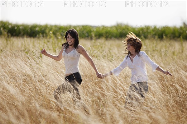 France, Picardie, Albert, Young women running through cornfield. 
Photo : Jan Scherders