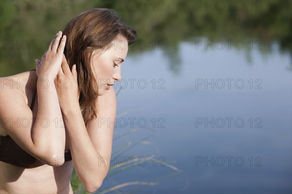 Portrait of young woman against lake. 
Photo : Jan Scherders