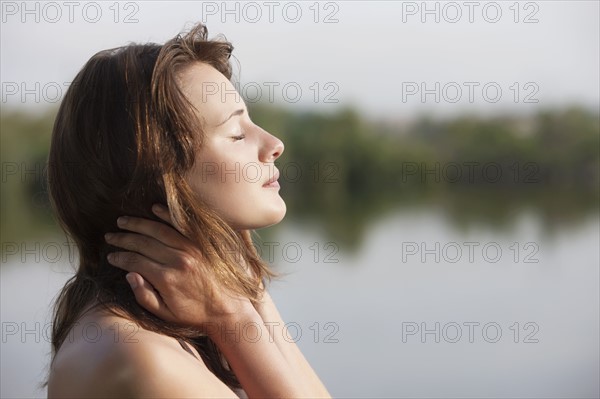 Portrait of young woman against lake. 
Photo : Jan Scherders