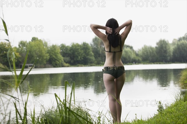 France, Picardie, Albert, Young woman in bikini standing on lake shore. 
Photo : Jan Scherders
