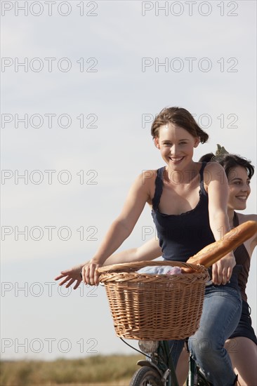 Young women on bikes on country road. 
Photo : Jan Scherders