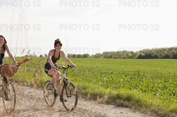 France, Picardie, Albert, Young women on bikes on country road. 
Photo: Jan Scherders