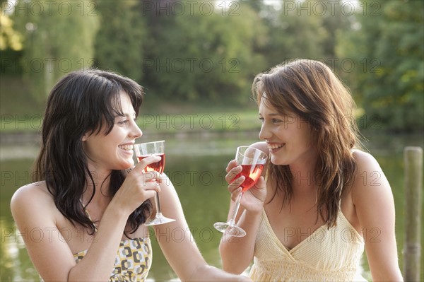 France, Picardie, Albert, Young women having picnic on lakeside. 
Photo : Jan Scherders