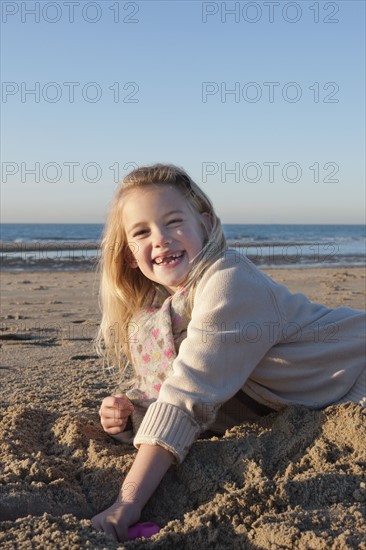 Netherlands, Zeeland, Haamstede, Girl digging sand on beach. 
Photo : Jan Scherders