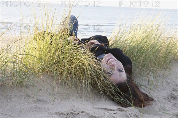 Netherlands, Zeeland, Haamstede, Woman lying on sand dune. 
Photo : Jan Scherders