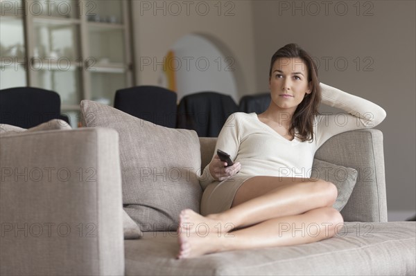 Portrait of woman sitting on couch. 
Photo : Jan Scherders