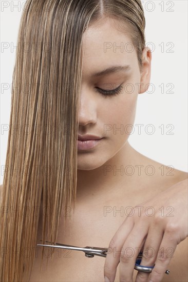 Portrait of young woman with wet hair and scissors. 
Photo : Jan Scherders