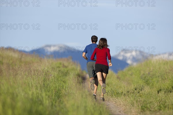 USA, Montana, Kalispell, Couple jogging in mountainside. 
Photo : Noah Clayton