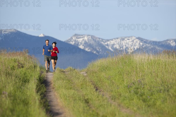 USA, Montana, Kalispell, Couple jogging in mountainside. 
Photo : Noah Clayton