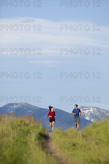 USA, Montana, Kalispell, Couple jogging in mountainside. 
Photo: Noah Clayton