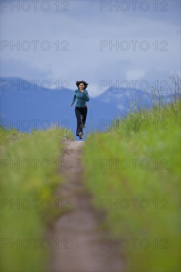 USA, Montana, Whitefish, Woman jogging on mountain path. 
Photo: Noah Clayton