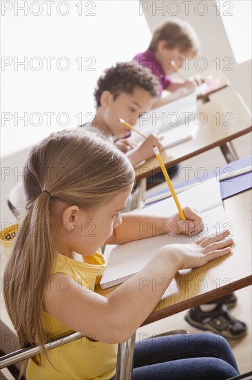 Schoolchildren focused on writing in classroom.
Photo : Rob Lewine