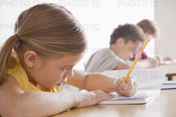 Schoolchildren focused on writing in classroom. 
Photo : Rob Lewine