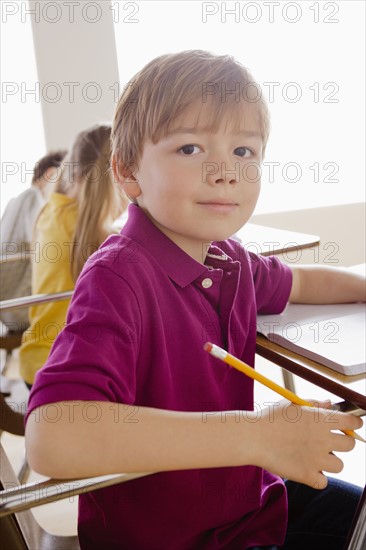 Schoolboy holding pencil in classroom.
Photo: Rob Lewine