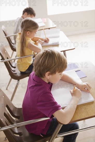 Schoolchildren focused on writing in classroom.
Photo: Rob Lewine