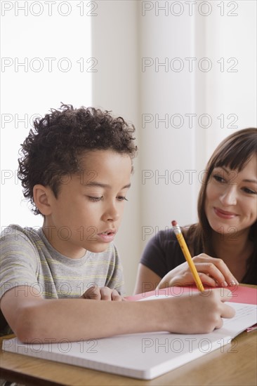 Pupil writing together with teacher. 
Photo : Rob Lewine