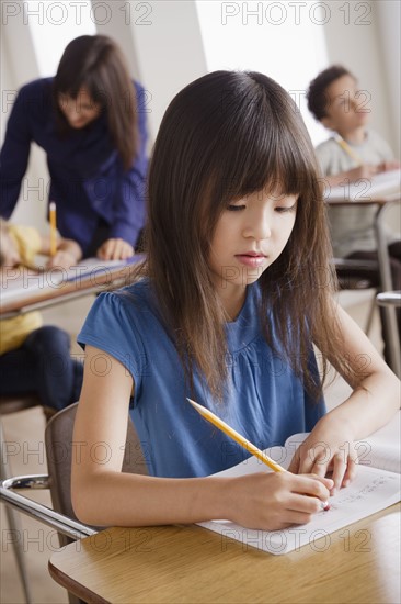 Schoolgirl focused on writing. 
Photo : Rob Lewine