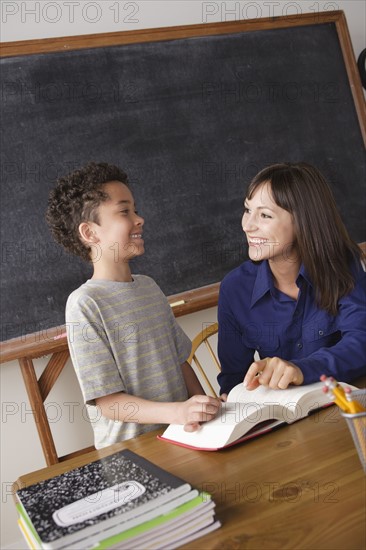 Schoolboy reading with teacher in classroom. 
Photo : Rob Lewine