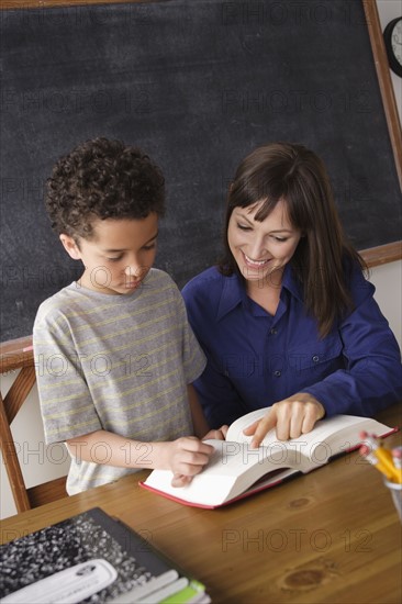 Schoolboy reading with teacher in classroom. 
Photo : Rob Lewine