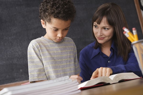 Schoolboy reading with teacher in classroom. 
Photo : Rob Lewine