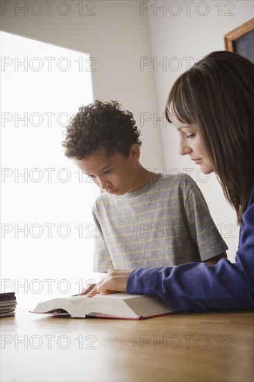 Schoolboy reading with teacher in classroom. 
Photo: Rob Lewine