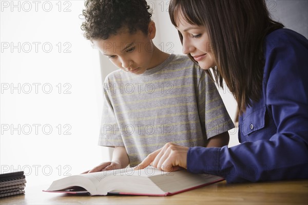 Schoolboy reading with teacher in classroom. 
Photo : Rob Lewine