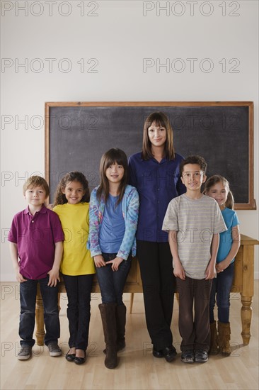 Teacher with group of pupils in front of blackboard. 
Photo : Rob Lewine