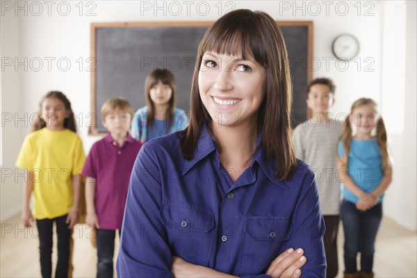 Teacher with group of pupils in front of blackboard. 
Photo : Rob Lewine