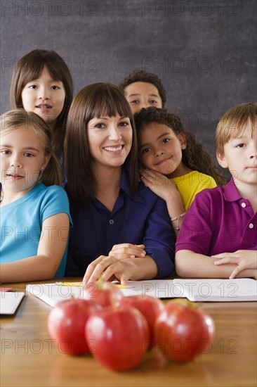 Teacher with group of pupils and apples on desk. 
Photo : Rob Lewine