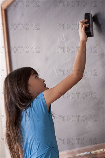 Schoolgirl writing on blackboard. 
Photo : Rob Lewine