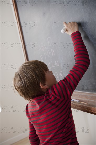 Schoolboy writing on blackboard. 
Photo: Rob Lewine