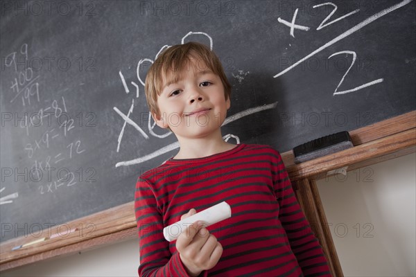 Schoolboy writing on blackboard. 
Photo : Rob Lewine