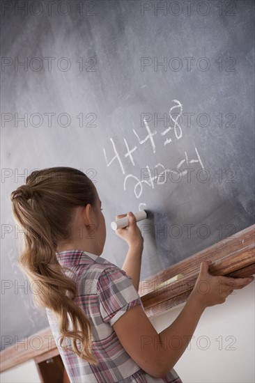 Schoolboy writing on blackboard. 
Photo : Rob Lewine