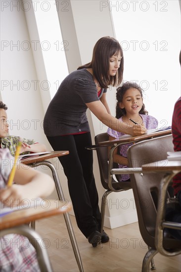 Teacher helping schoolchildren (6-7,8-9). 
Photo : Rob Lewine