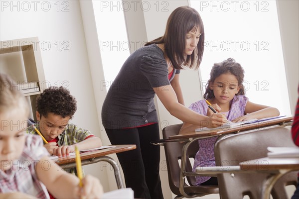 Teacher helping schoolchildren (6-7,8-9). 
Photo : Rob Lewine