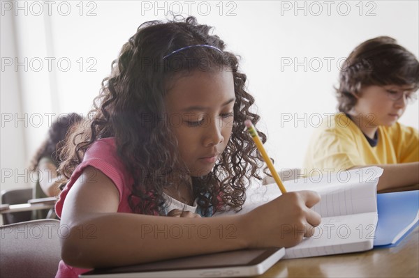 Portrait of schoolgirl (10-11) writing. 
Photo : Rob Lewine