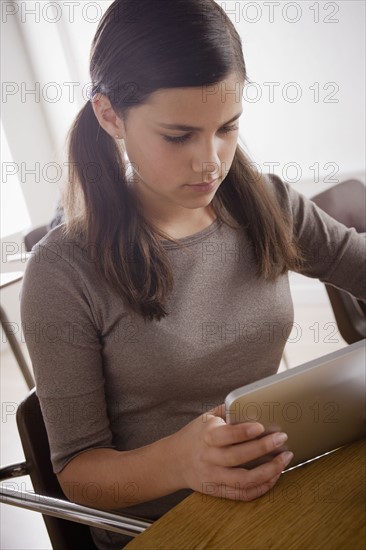 Portrait of schoolgirl (12-13) with digital tablet. 
Photo: Rob Lewine