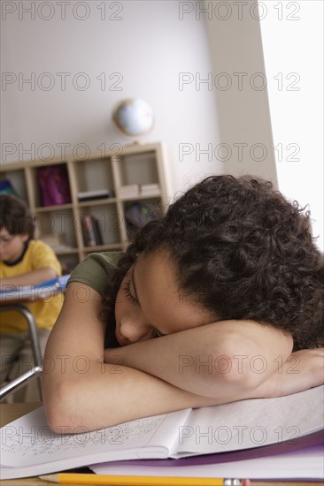 Girl (10-11) napping on desk with boy (10-11) in background. 
Photo : Rob Lewine