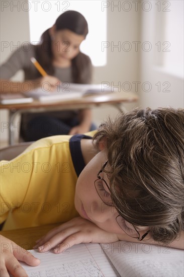 Boy (10-11) napping on desk with girl (12-13) in background. 
Photo: Rob Lewine