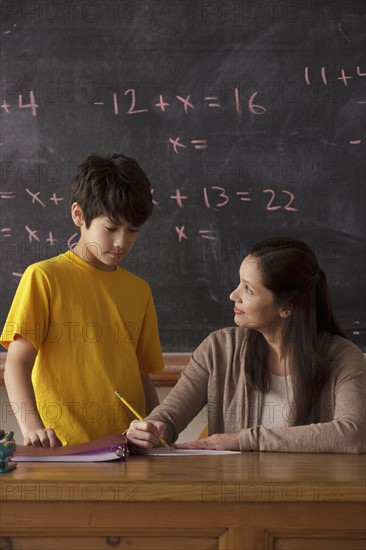 Schoolboy (12-13) and teacher with blackboard in background. 
Photo : Rob Lewine