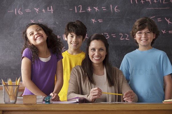 Portrait of pupils (10-11, 12-13) and teacher with blackboard in background. 
Photo : Rob Lewine