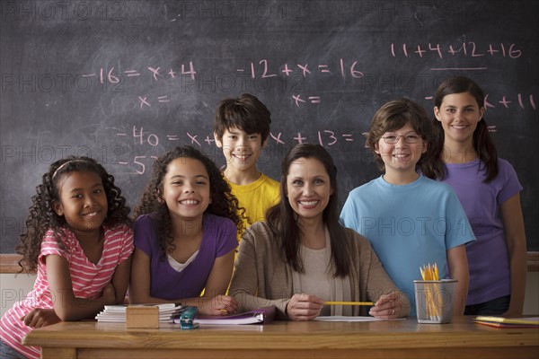 Portrait of pupils (10-11, 12-13) and teacher with blackboard in background. 
Photo : Rob Lewine