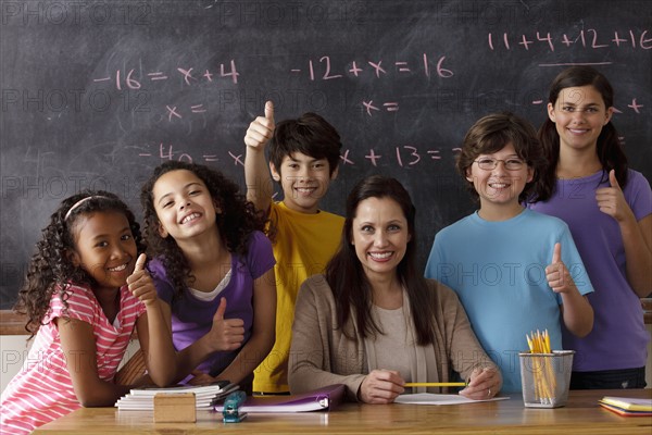 Portrait of pupils (10-11, 12-13) and teacher with blackboard in background. 
Photo : Rob Lewine