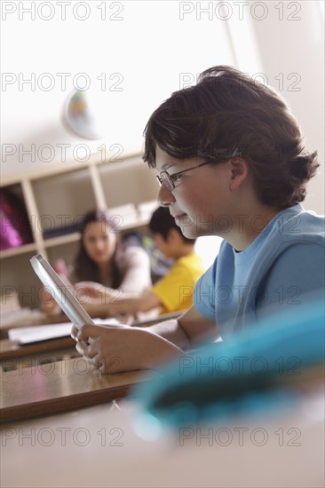 Portrait of schoolboy (10-11) with digital tablet. 
Photo: Rob Lewine