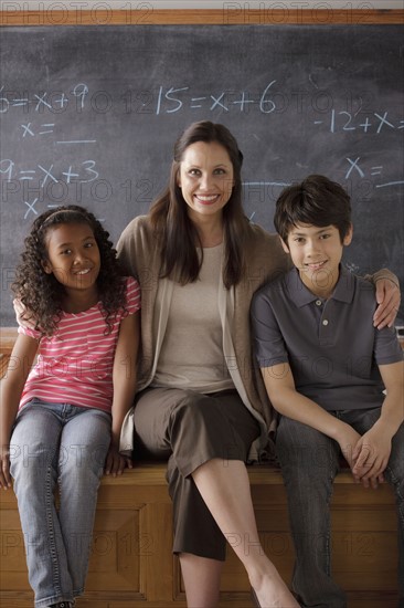 Portrait of teacher in classroom with schoolboy (10-11) and schoolgirl (12-13). 
Photo : Rob Lewine