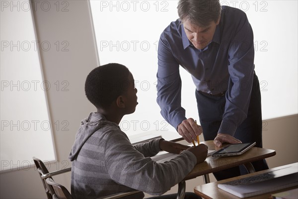 Teenage boy (14-15) with teacher at school. 
Photo : Rob Lewine