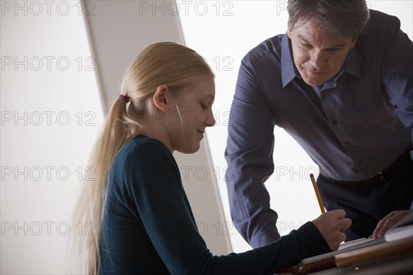 Teenage girl (14-15) with teacher at school. 
Photo : Rob Lewine