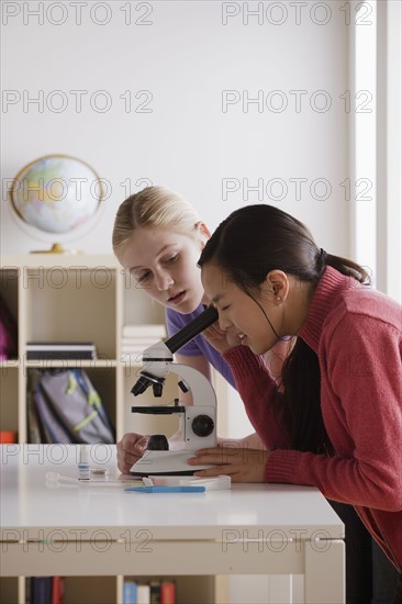 Teenage girls (14-15) working with microscope. 
Photo : Rob Lewine