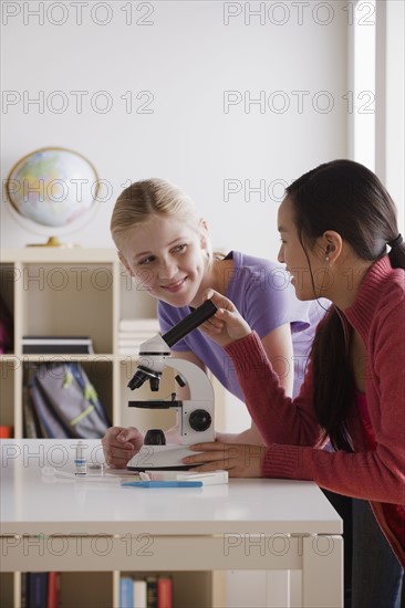 Teenage girls (14-15) working with microscope. 
Photo: Rob Lewine