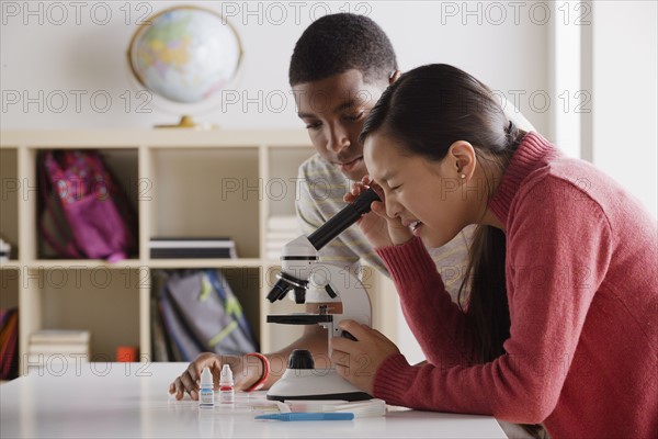 Teenage students (14-15) working with microscope. 
Photo : Rob Lewine